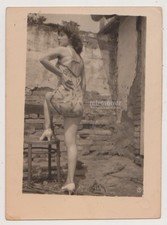 Foto de mulher de salto alto e vestido curto batendo uma pose em ruínas contra parede de tijolos comprar usado  Enviando para Brazil