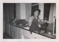 Jovem como cowboy sentado no balcão da cozinha e armas brandindo, década de 1960, usado comprar usado  Enviando para Brazil