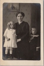 Cartão postal foto RPPC c1910s mãe séria com menino e menina / salão de casa comprar usado  Enviando para Brazil