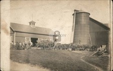 Fazenda agrícola RPPC com silo. Vários agricultores estão na frente vacas vagões feno. comprar usado  Enviando para Brazil