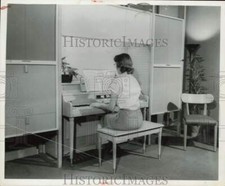1956 Press Photo Uma mulher toca piano cercada por armários embutidos comprar usado  Enviando para Brazil