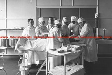 F001053 Cirurgiões e enfermeiras cuidando de um paciente em uma mesa de operação no King G comprar usado  Enviando para Brazil