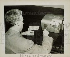 Foto de imprensa empresário enviando telegrama por mesa-fax máquina na Western Union comprar usado  Enviando para Brazil