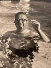 Foto vintage de hombre en la piscina sosteniendo cigarrillo sobre bola de agua flotando detrás de él, usado segunda mano  Embacar hacia Argentina
